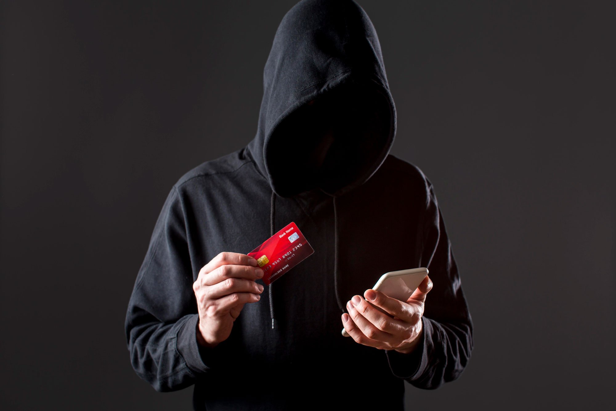 web.front-view-of-male-hacker-holding-smartphone-and-credit-card_0